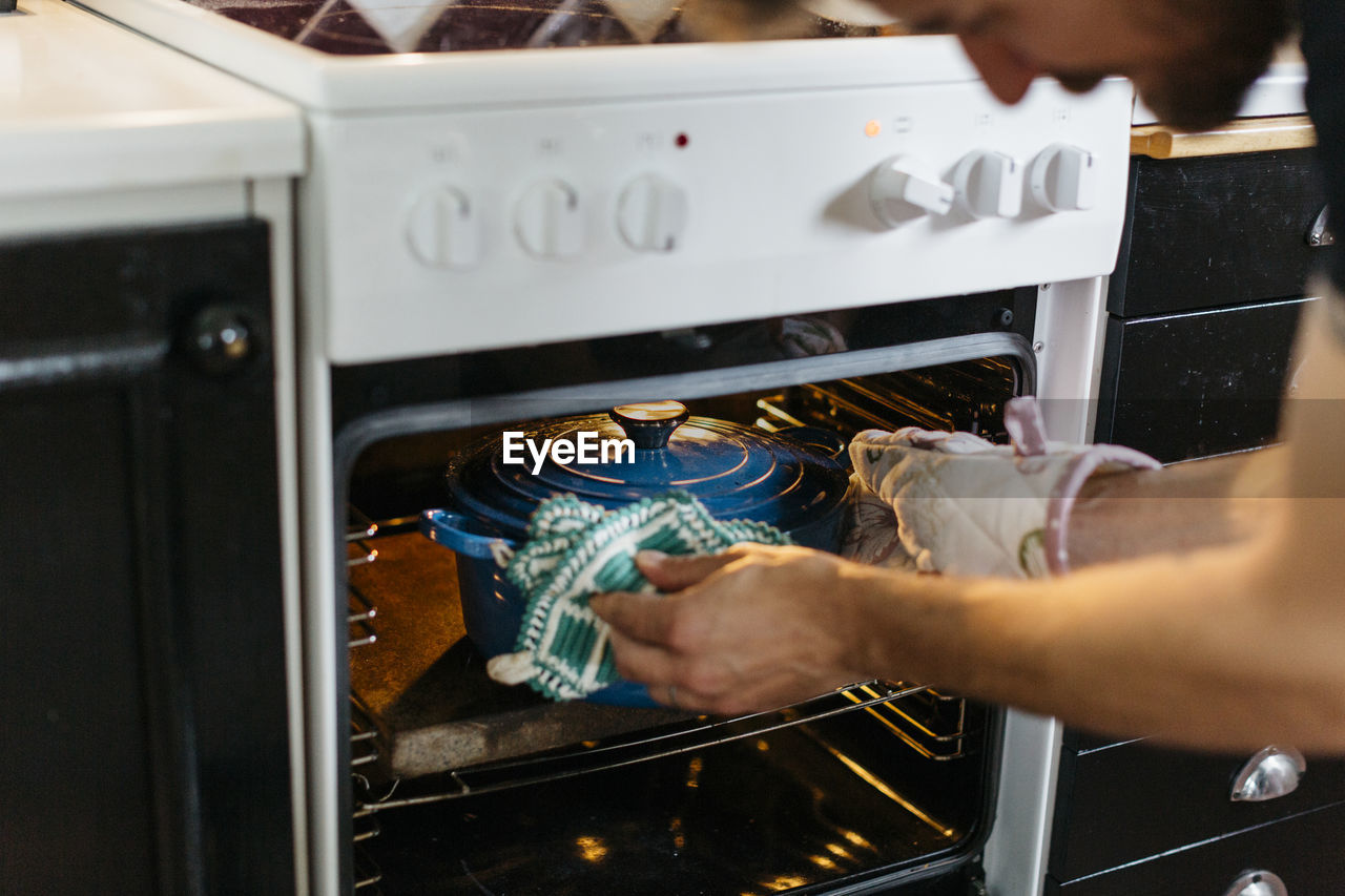 Man putting pot inside oven