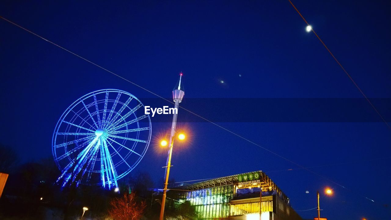 LOW ANGLE VIEW OF ILLUMINATED LAMP POST AGAINST BLUE SKY