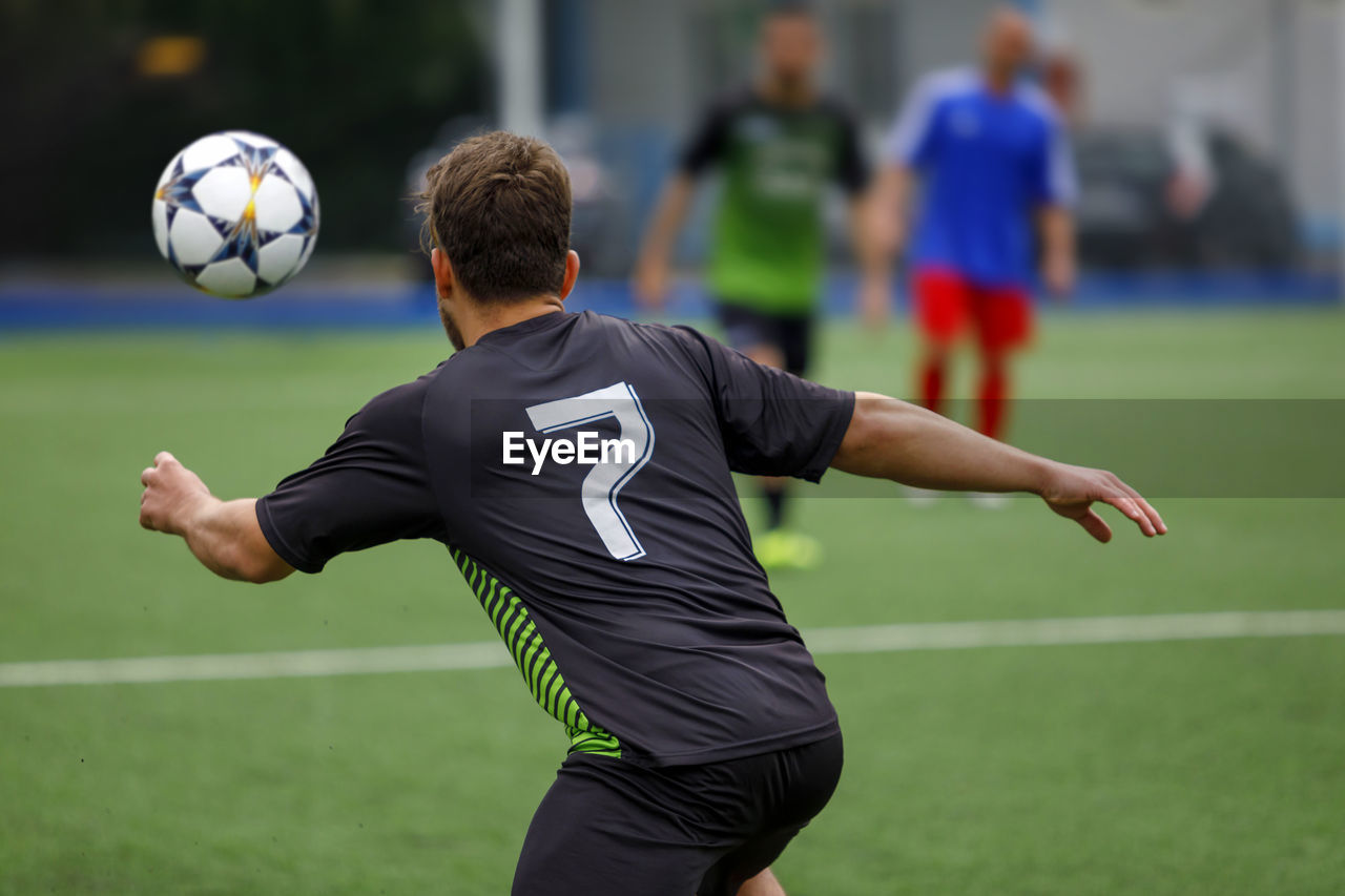 Rear view of soccer player playing field