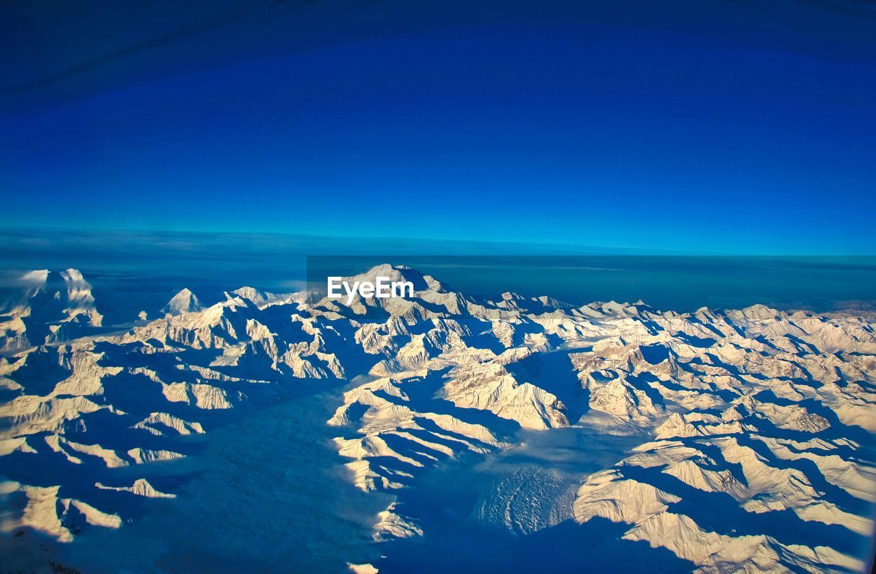 SCENIC VIEW OF SEA AND SNOWCAPPED MOUNTAINS AGAINST CLEAR SKY