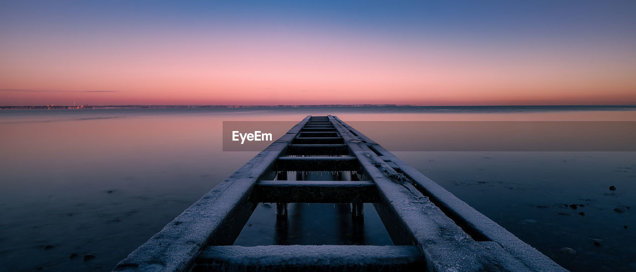 scenic view of sea against clear sky during sunset