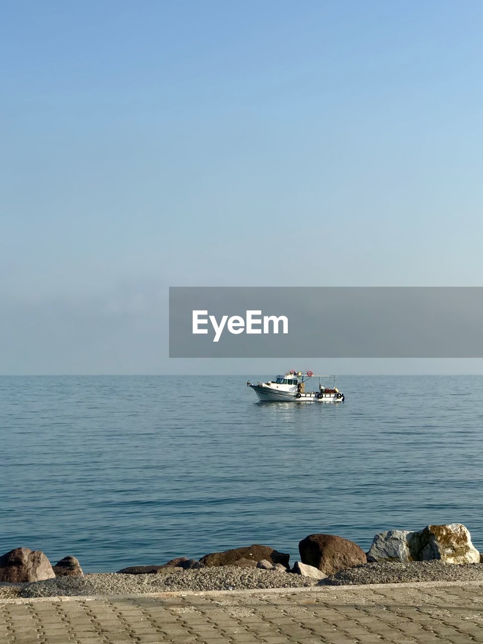 Sailboat on sea shore against sky