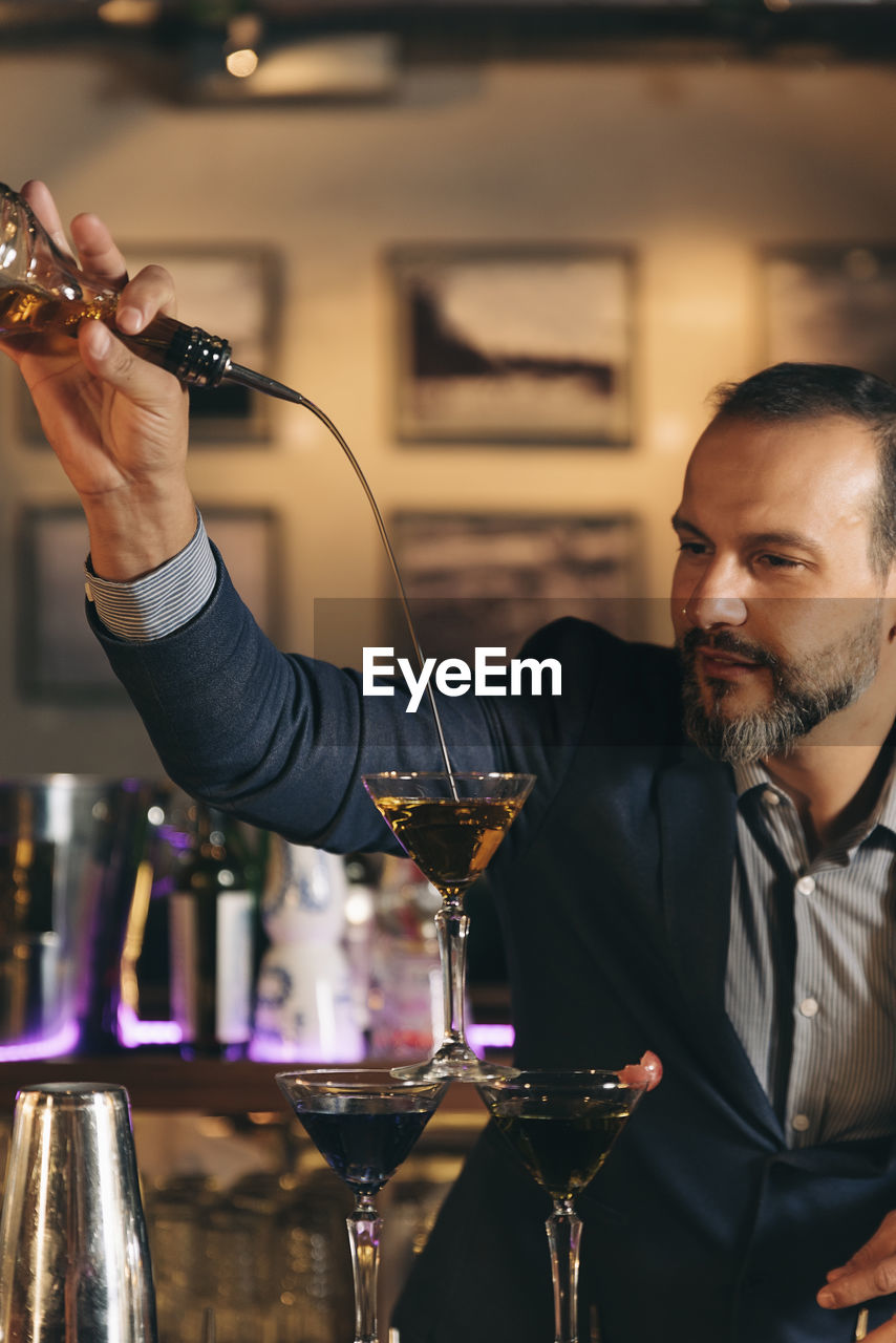 Male bartender preparing cocktail at bar counter