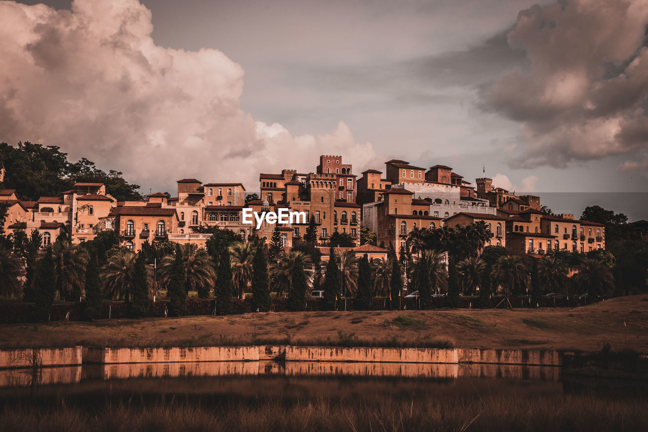 Panoramic view of buildings and trees against sky