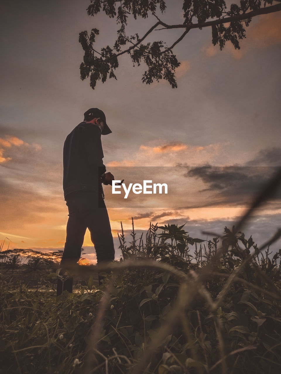 Full length of man standing against sky during sunset