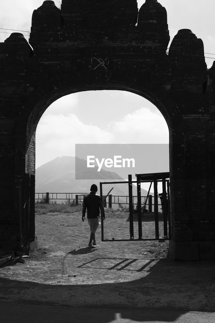 MAN WALKING IN OLD RUIN