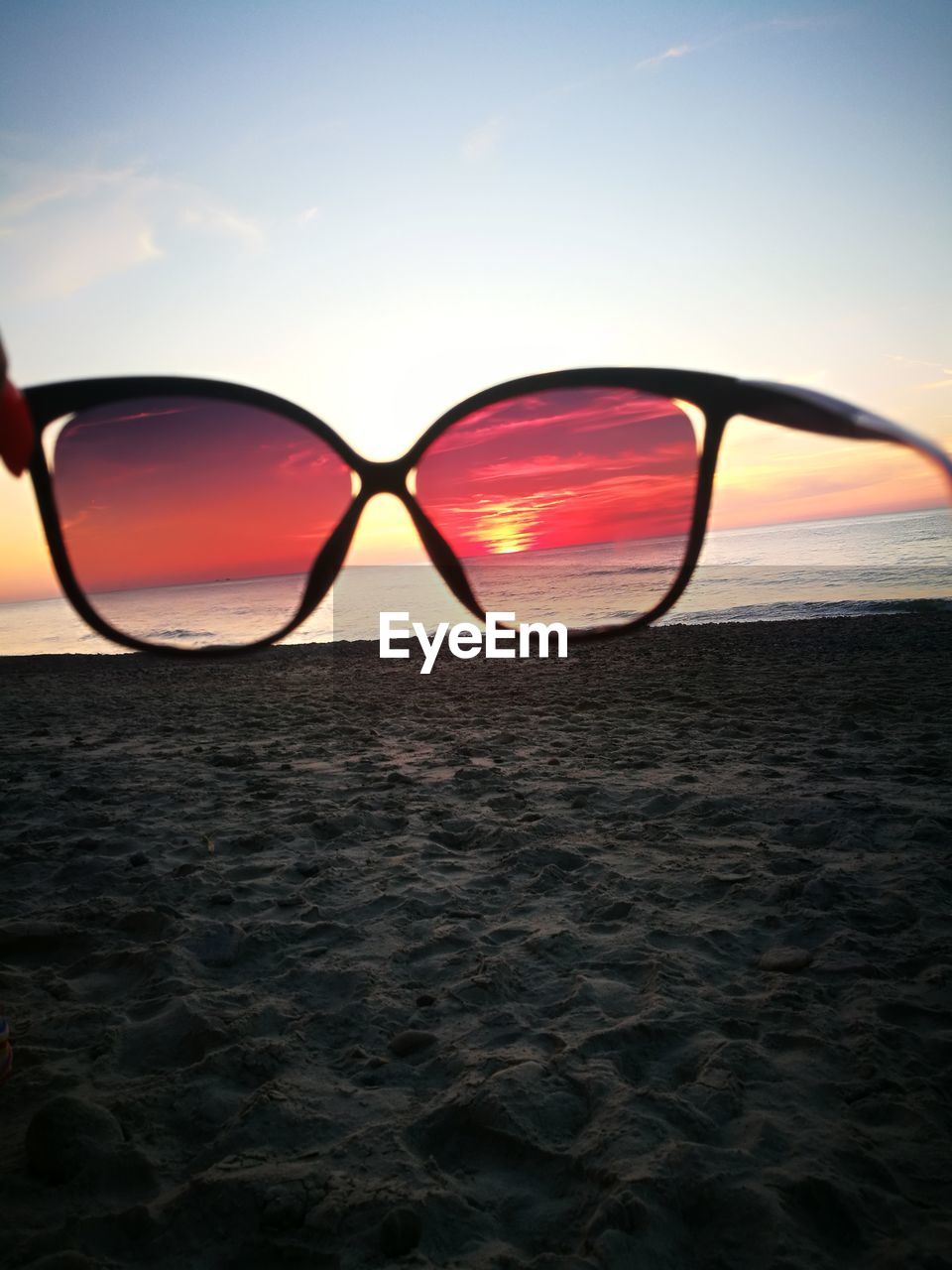 REFLECTION OF SUNGLASSES ON BEACH