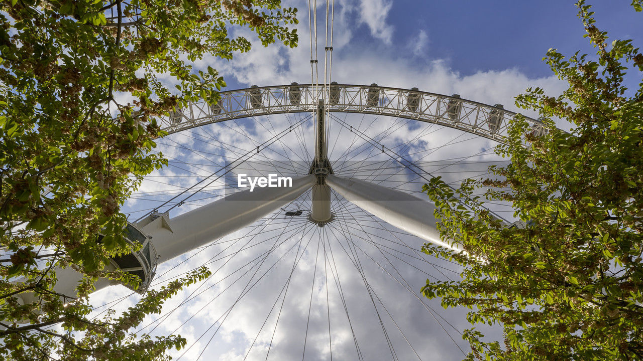 tree, plant, sky, architecture, nature, built structure, amusement park, amusement park ride, low angle view, arts culture and entertainment, no people, park, outdoors, cloud, travel destinations, ferris wheel, day, building exterior, sunlight, city, travel, tourism, landmark