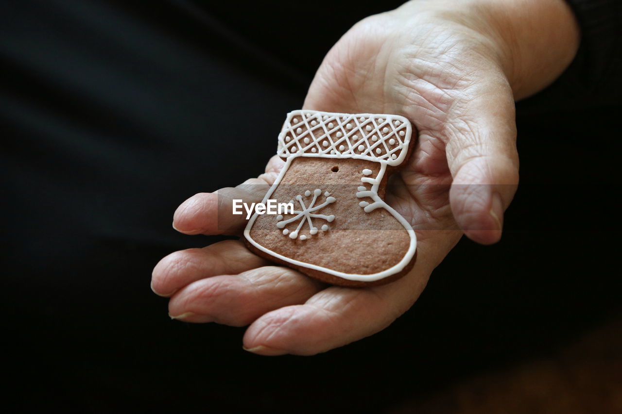 Close-up midsection of hand holding gingerbread cookie