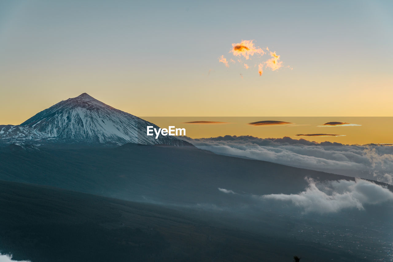 Scenic view of snowcapped mountains against sky during sunset