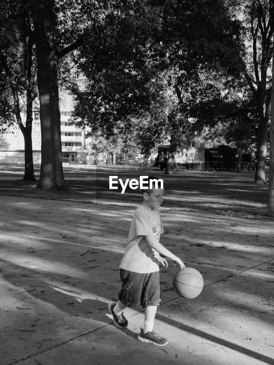 Full length of boy playing basketball at park