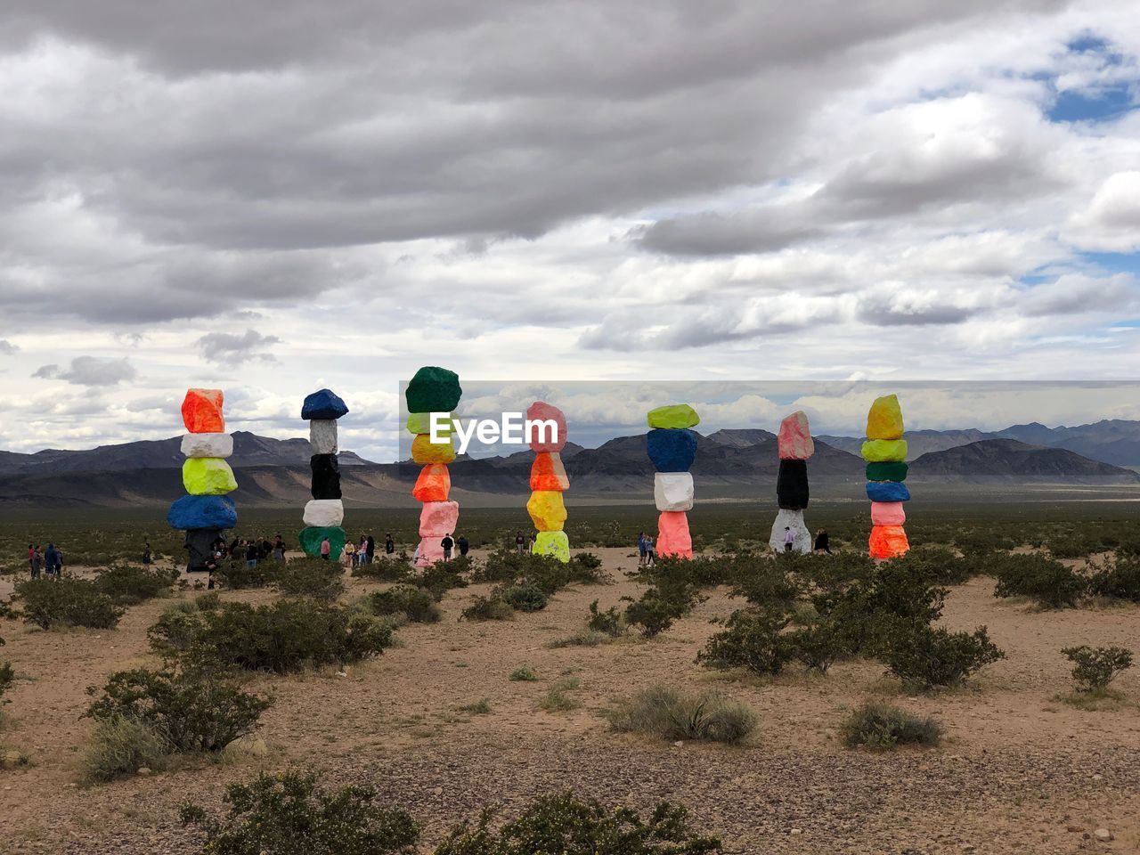 Multi colored rocks on land against cloudy sky