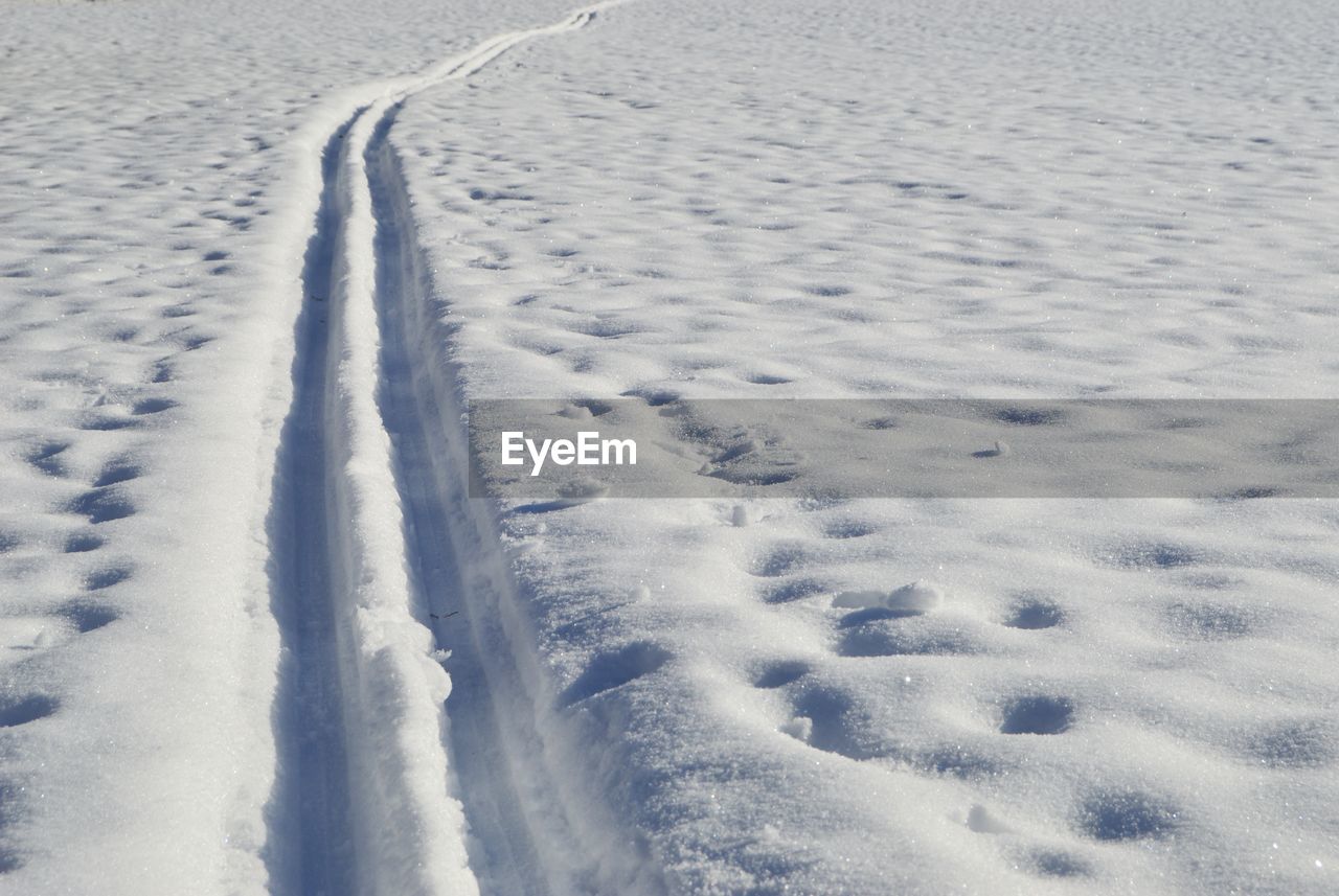 High angle view of footprints on snow covered field