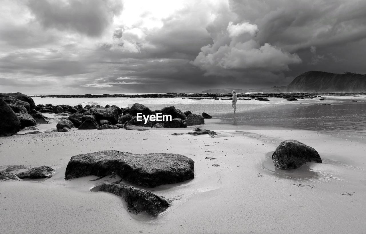 Scenic view of beach against dramatic sky