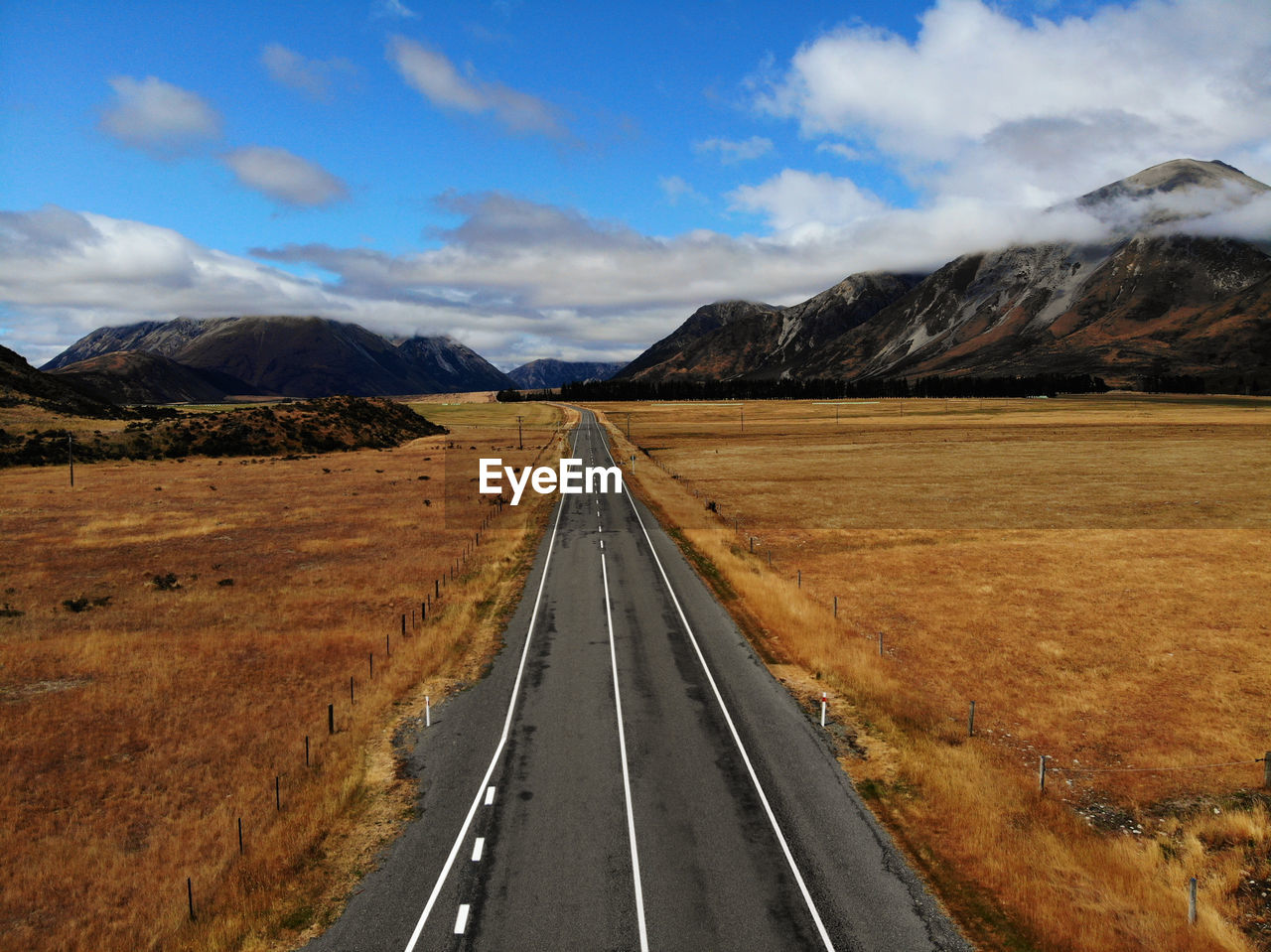 EMPTY ROAD LEADING TOWARDS MOUNTAINS