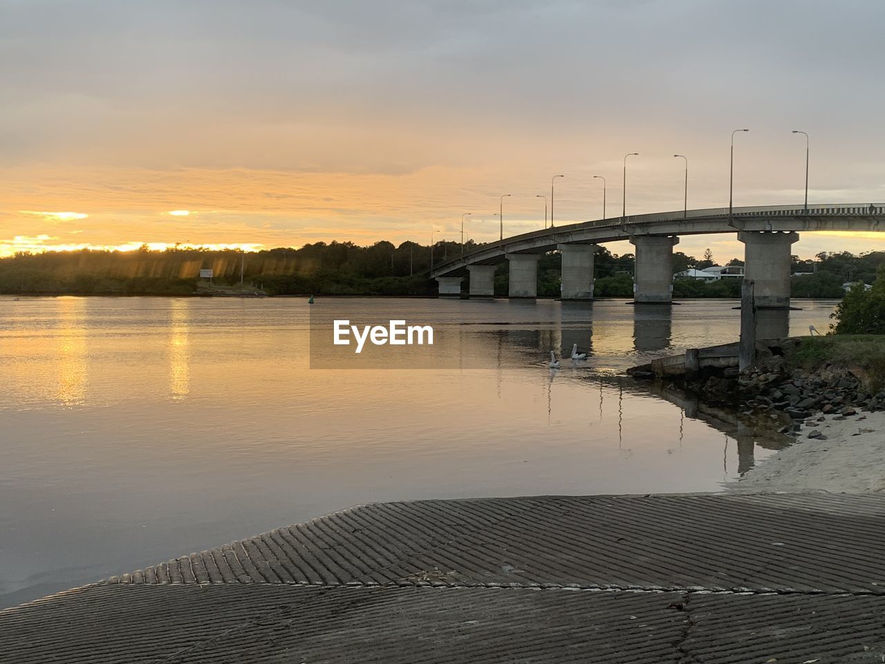 VIEW OF BRIDGE OVER RIVER AGAINST SKY DURING SUNSET