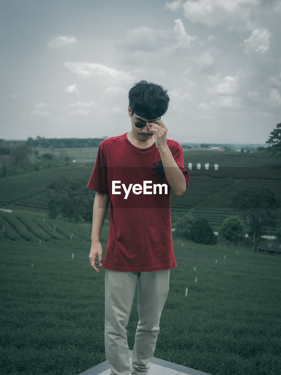 WOMAN STANDING ON FIELD AGAINST SKY