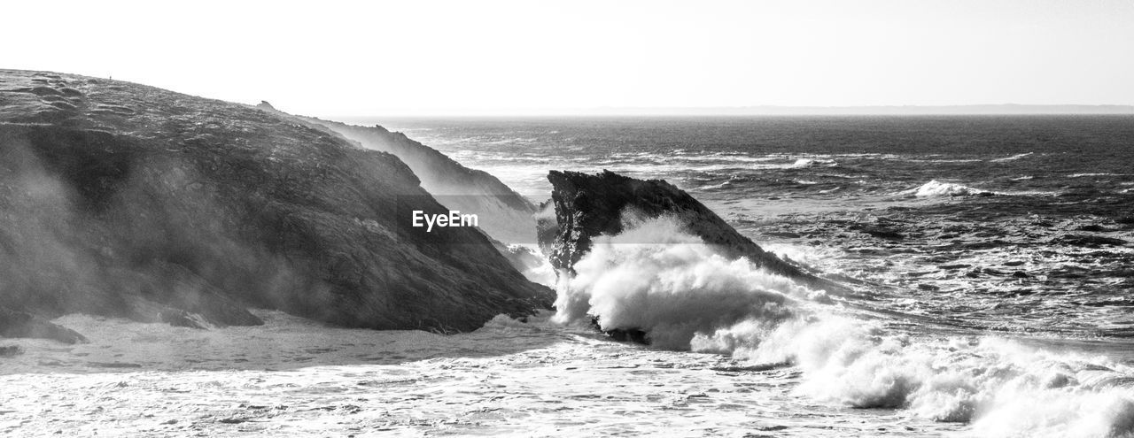 SCENIC VIEW OF SEA WAVES SPLASHING ON ROCKS