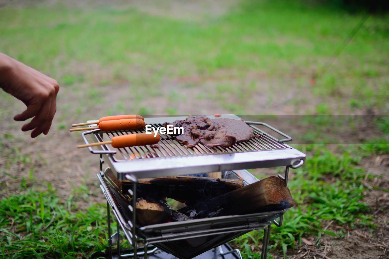 Person preparing food on barbecue grill