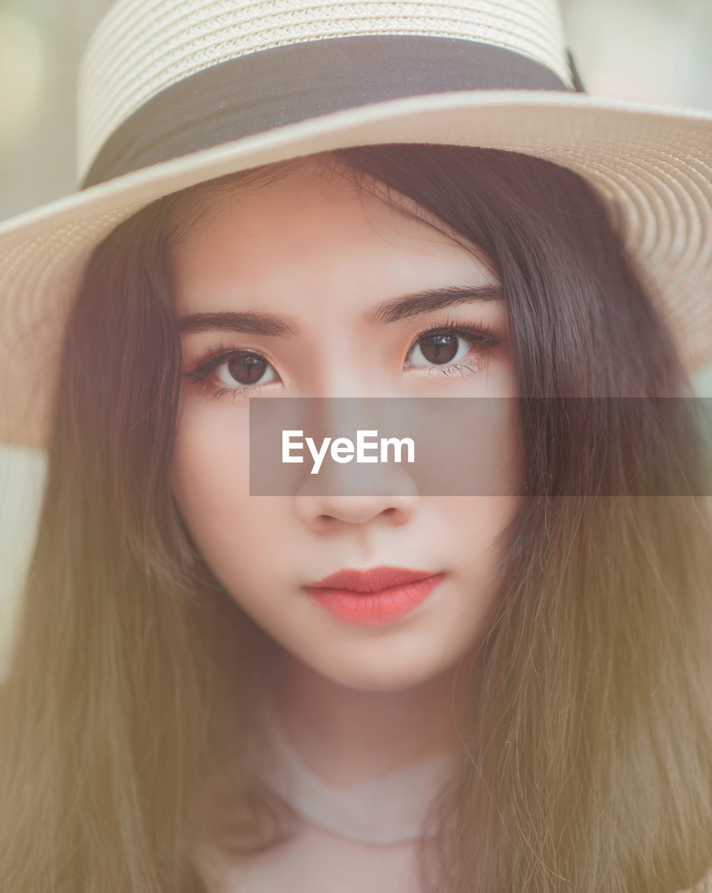 Close-up portrait of young woman in sun hat