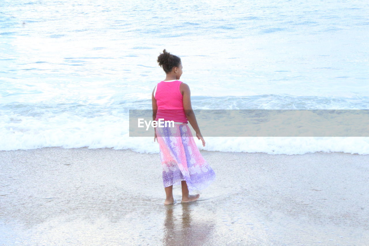 WOMAN STANDING ON BEACH