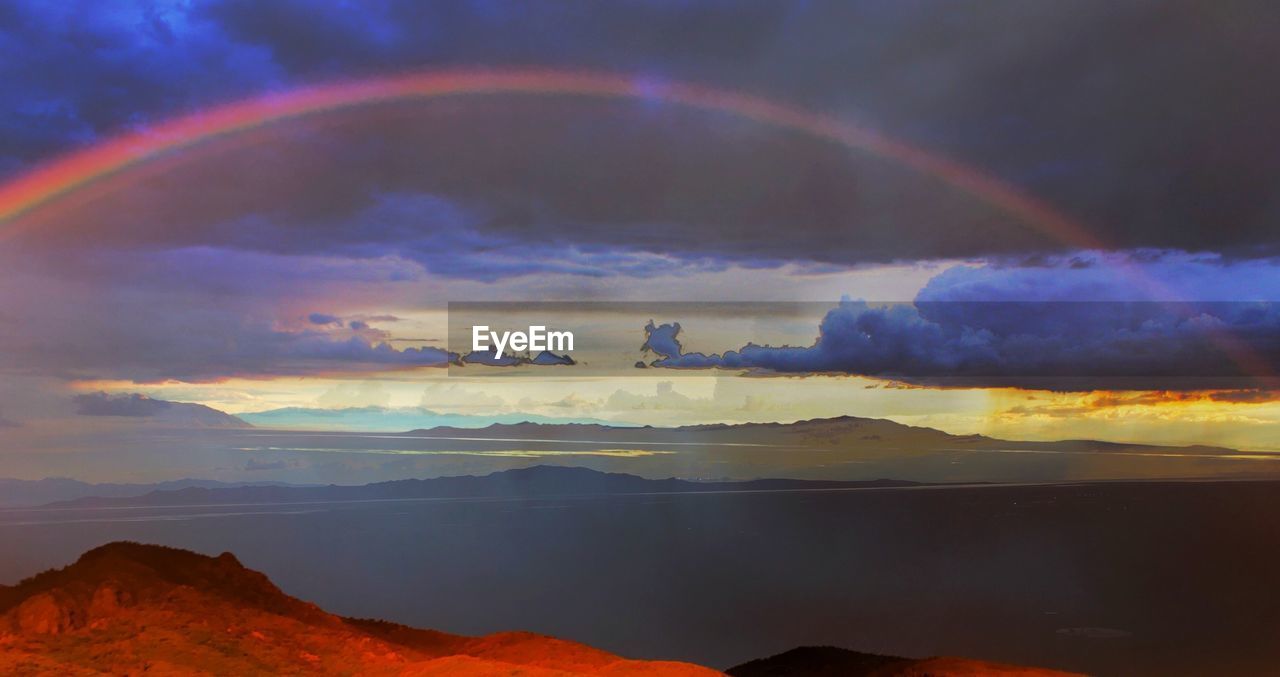 Scenic view of rainbow over landscape against sky