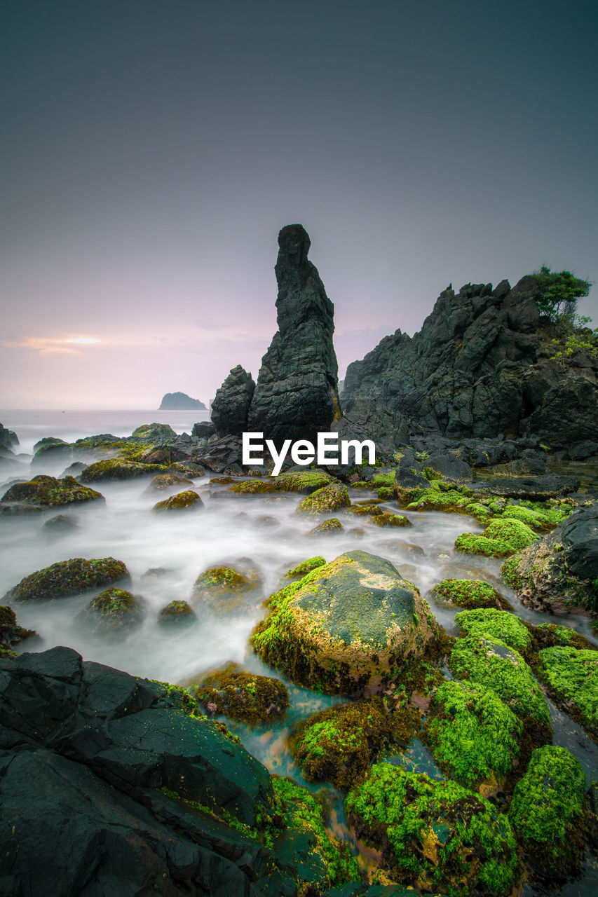 ROCKS ON BEACH AGAINST SKY