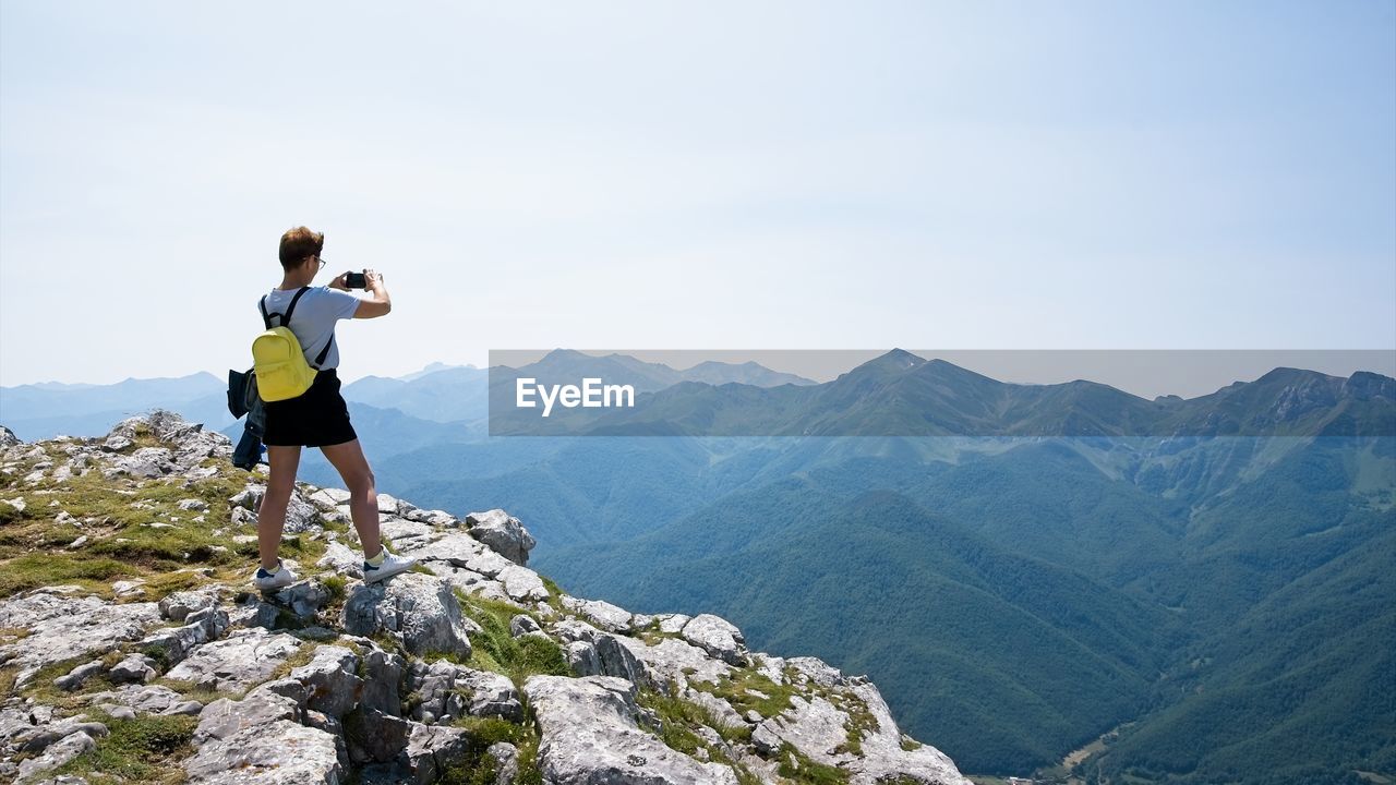 Woman takes photos at the top of the mountain