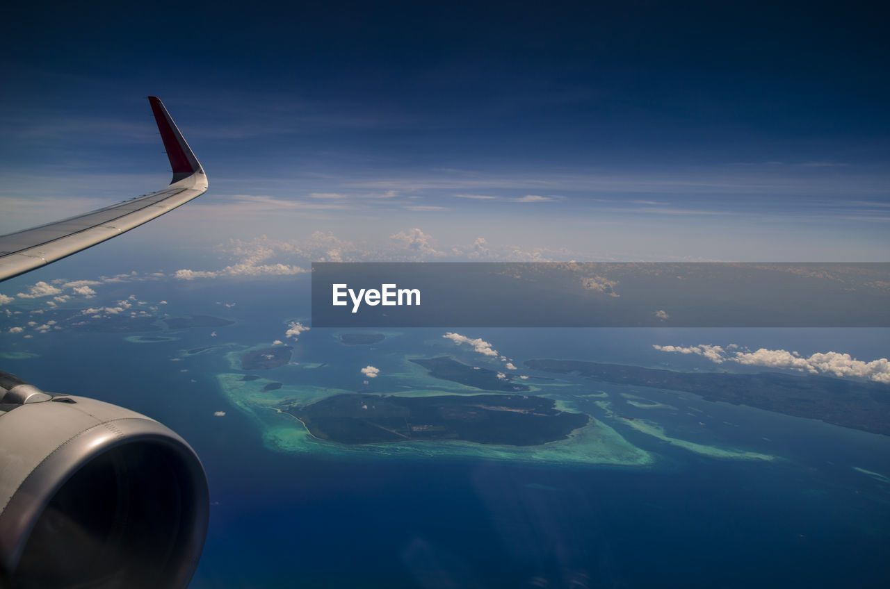 CROPPED IMAGE OF AIRPLANE OVER LANDSCAPE