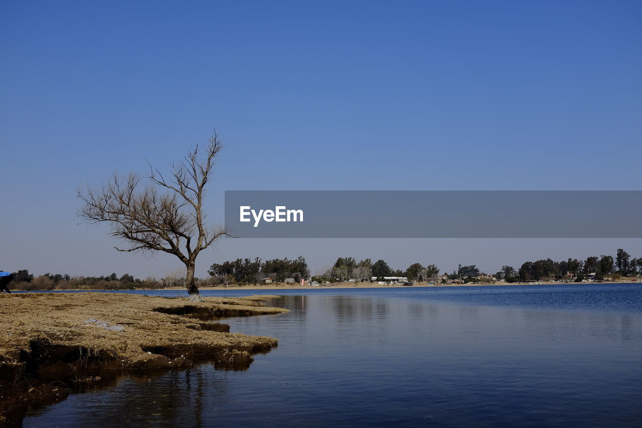 Scenic view of lake against clear blue sky