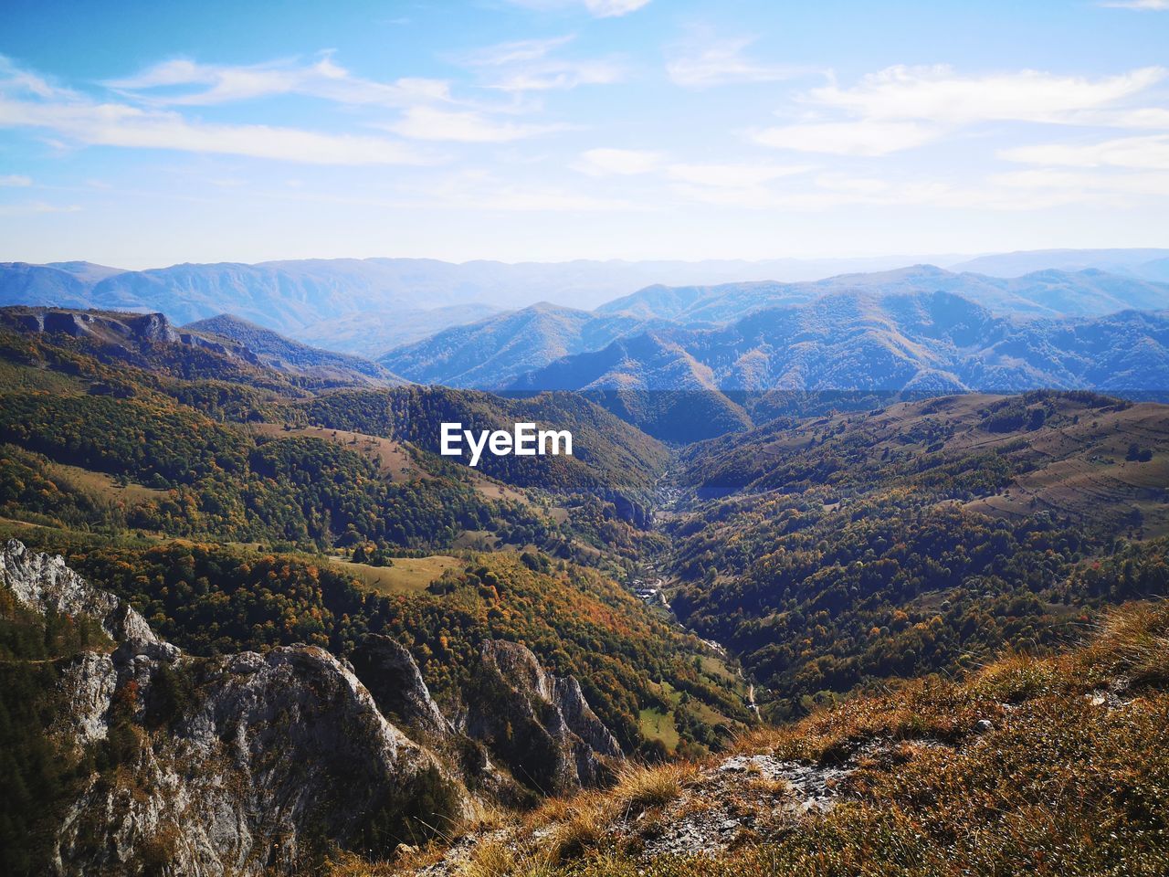 Scenic view of valley and mountains against sky