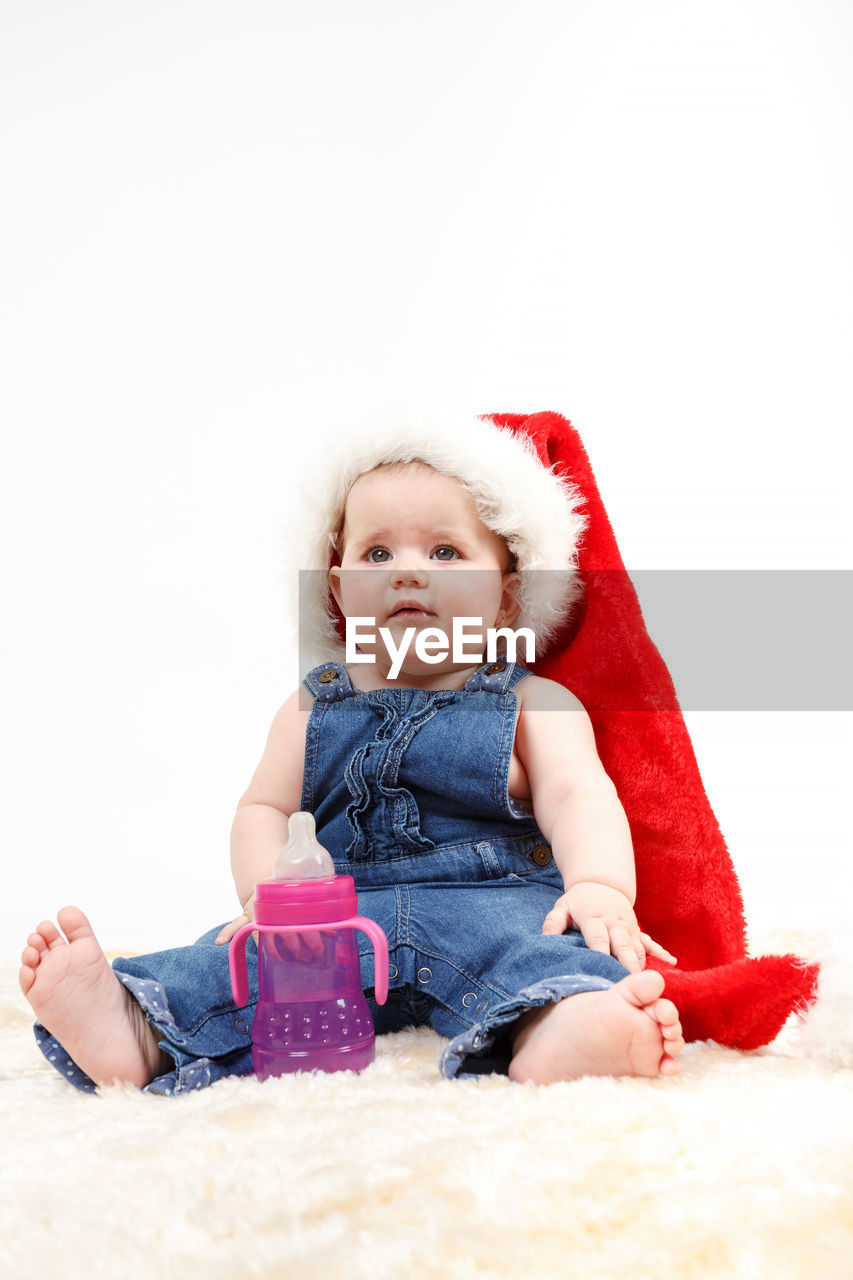 PORTRAIT OF CUTE BABY GIRL OVER WHITE BACKGROUND