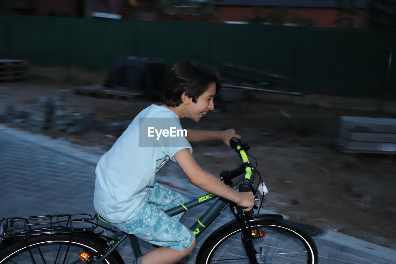 SIDE VIEW OF WOMAN RIDING BICYCLE ON A MOTORCYCLE