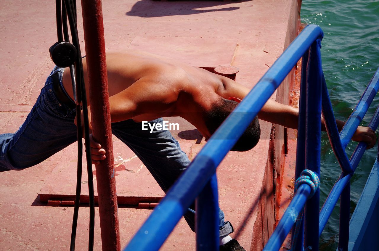 High angle view of shirtless man stretching