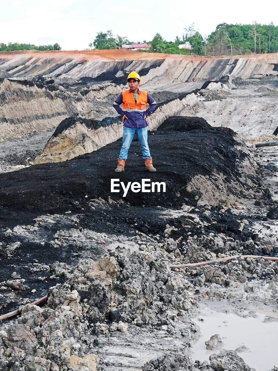 Full length of mid adult man standing on rock formation at construction site