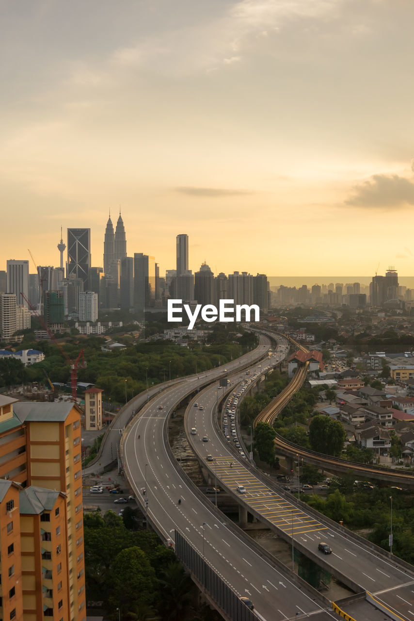 High angle view of bridges in city at sunset