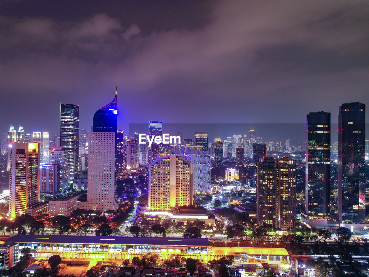 Illuminated buildings in city against sky at night