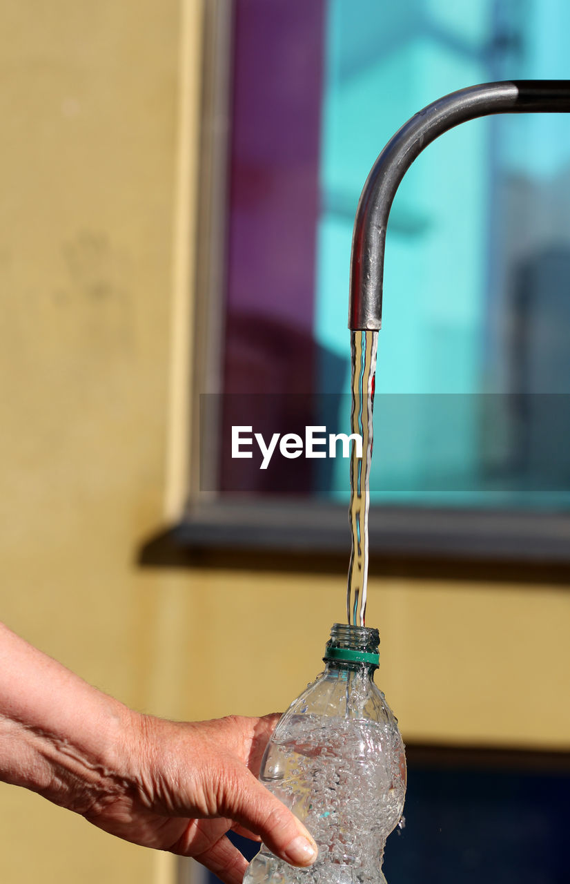 Close-up of water flowing into bottle