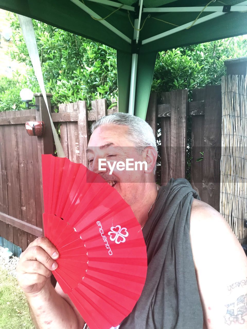 PORTRAIT OF MAN HOLDING RED UMBRELLA