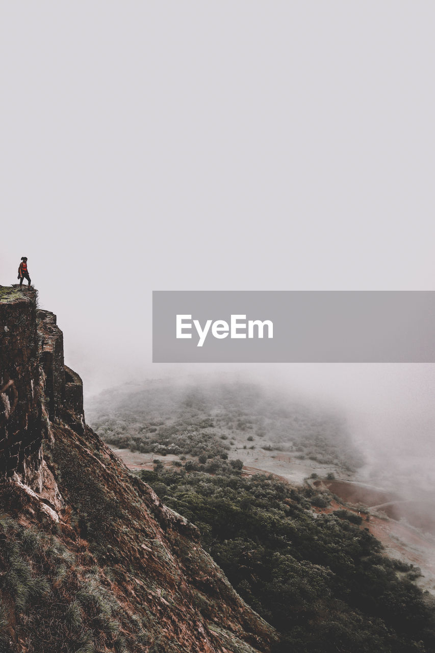 Woman standing on mountains against sky