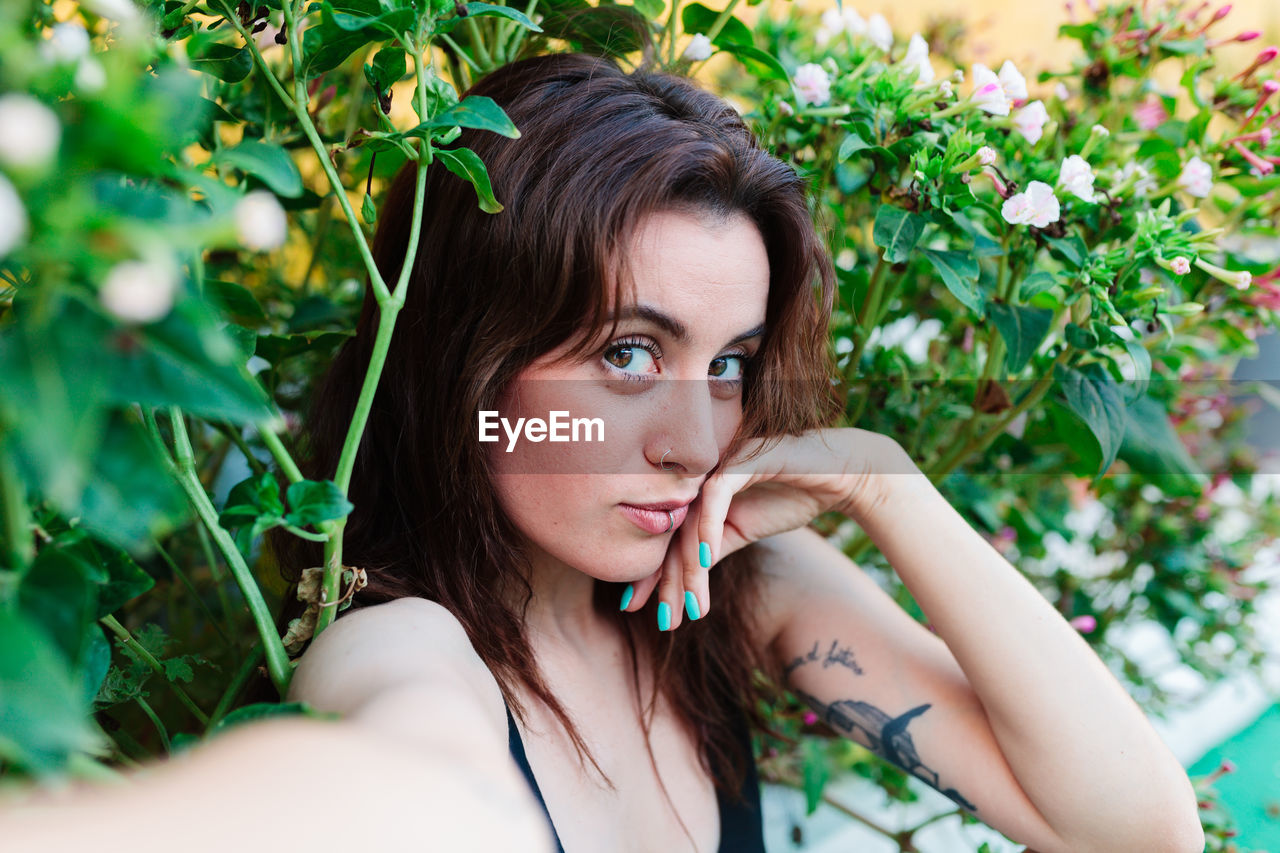 Photo of adorable young woman making selfie outdoors backyard