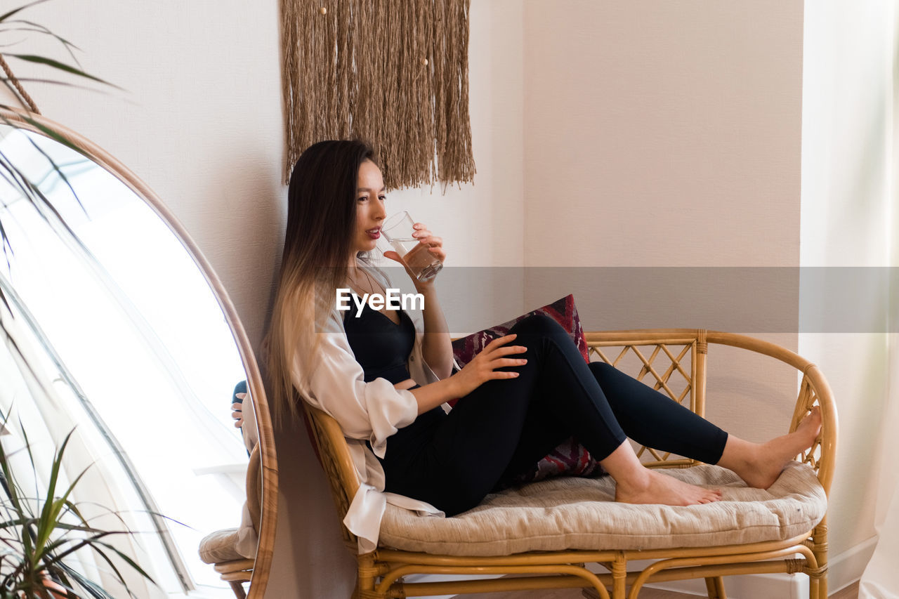 Woman drinking water at home