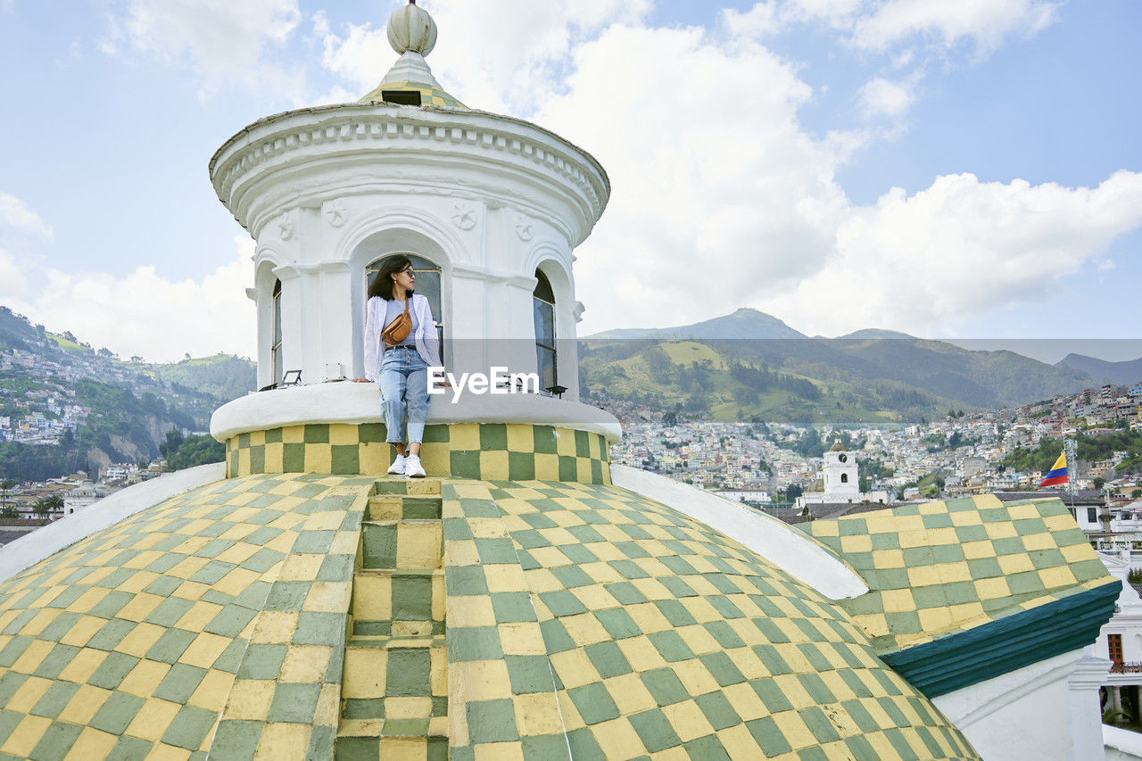 Young woman sitting on dome at cathedral of quito