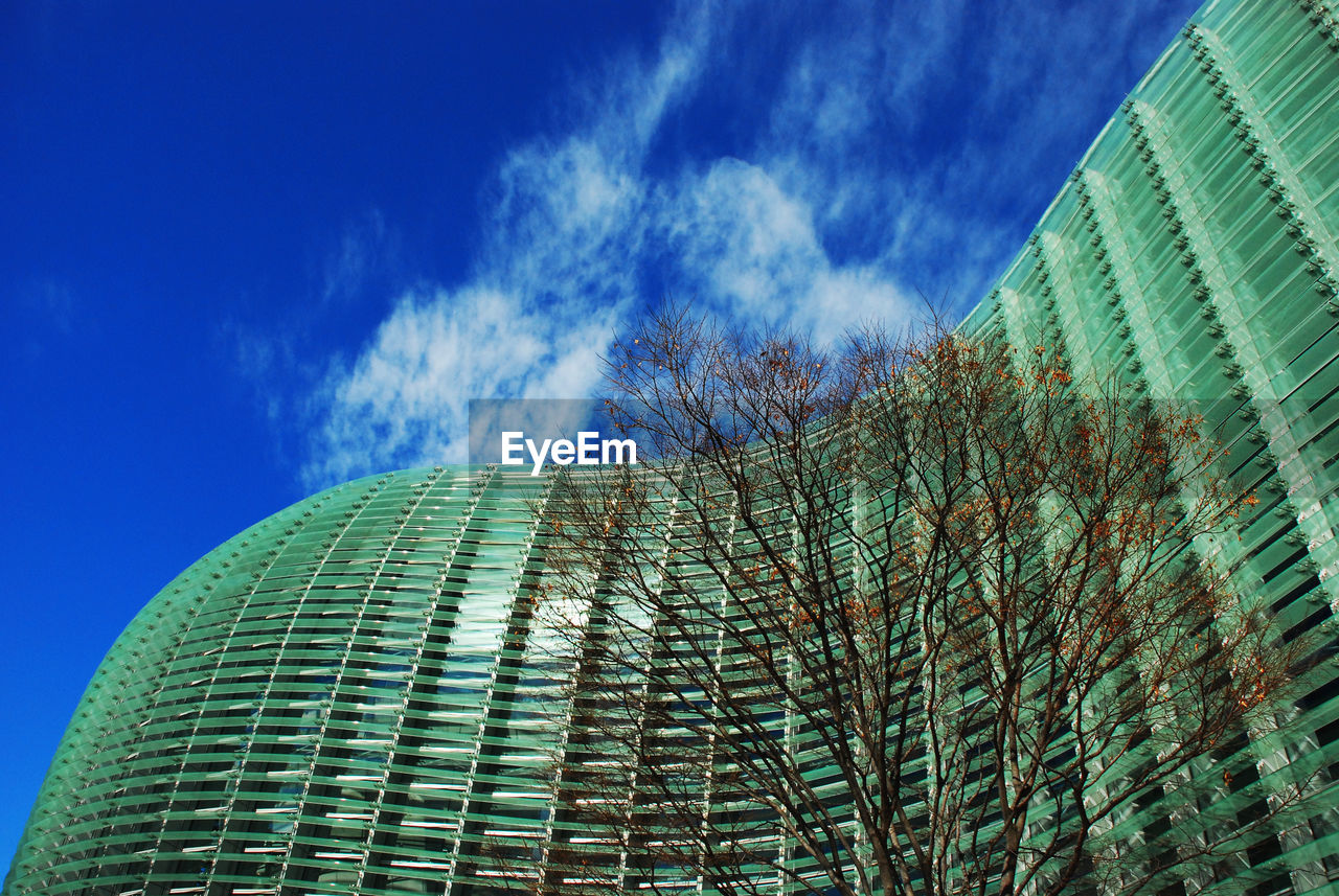 Low angle view of modern building against cloudy sky