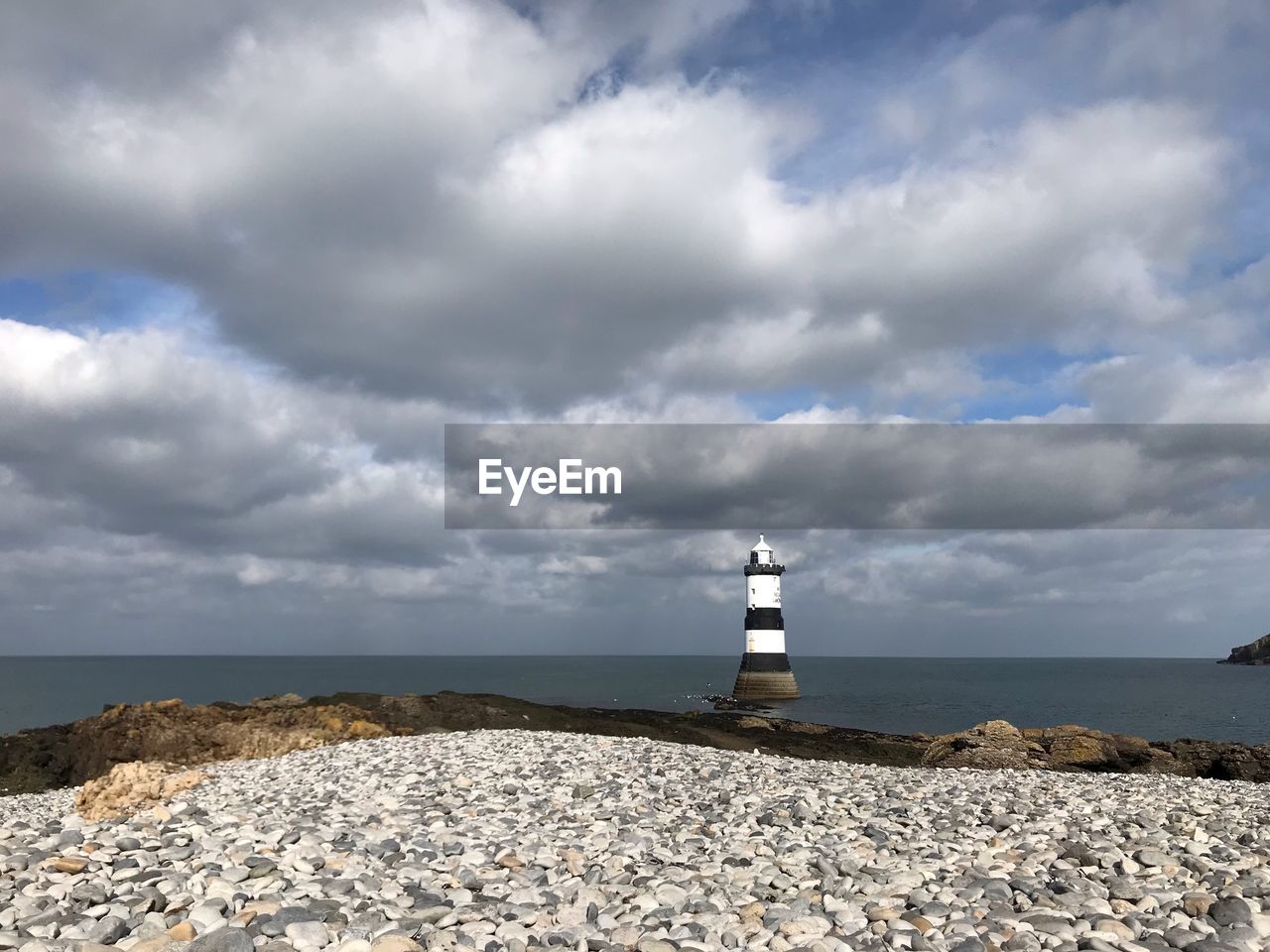 LIGHTHOUSE ON BEACH AGAINST SKY