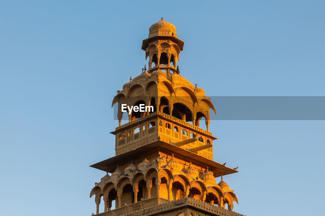 Low angle view of historical building against clear blue sky