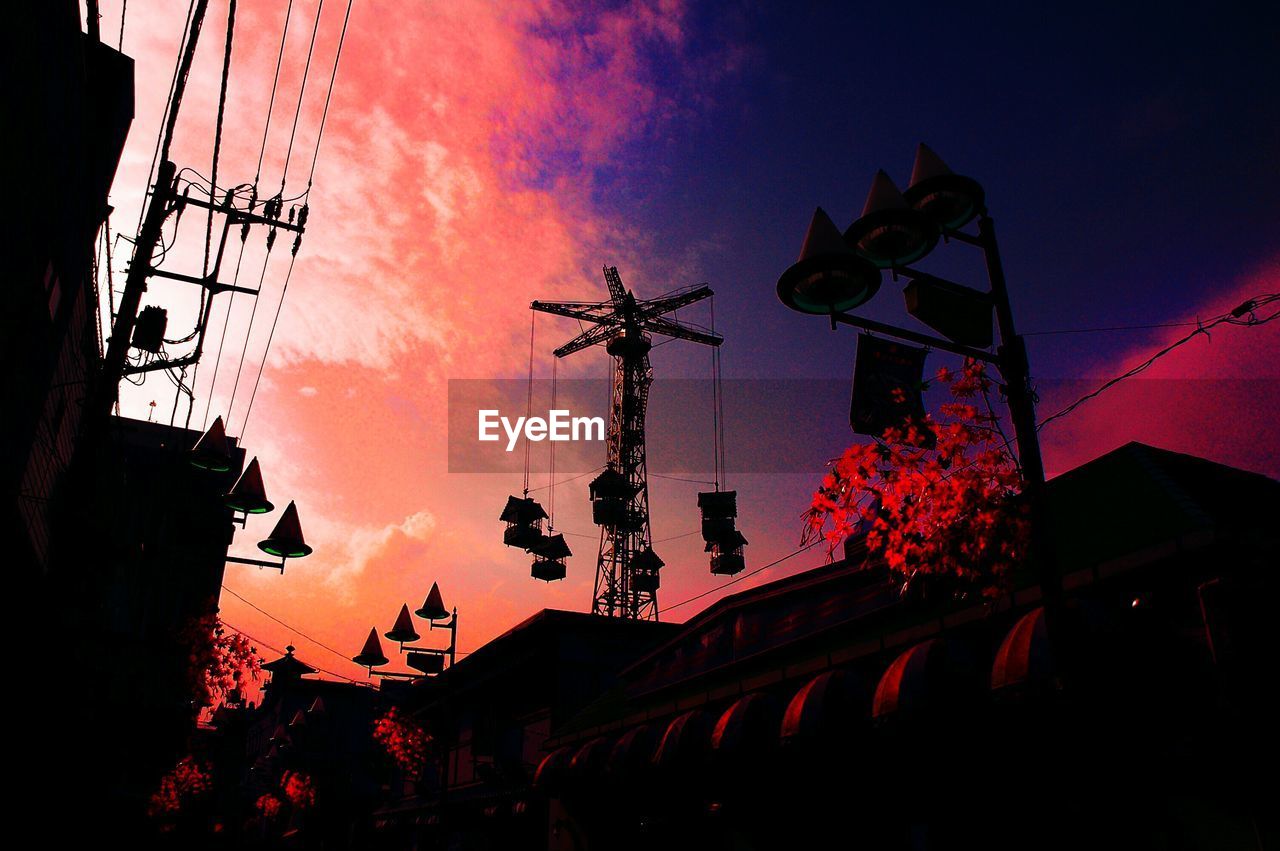 Low angle view of chain swing ride against sky