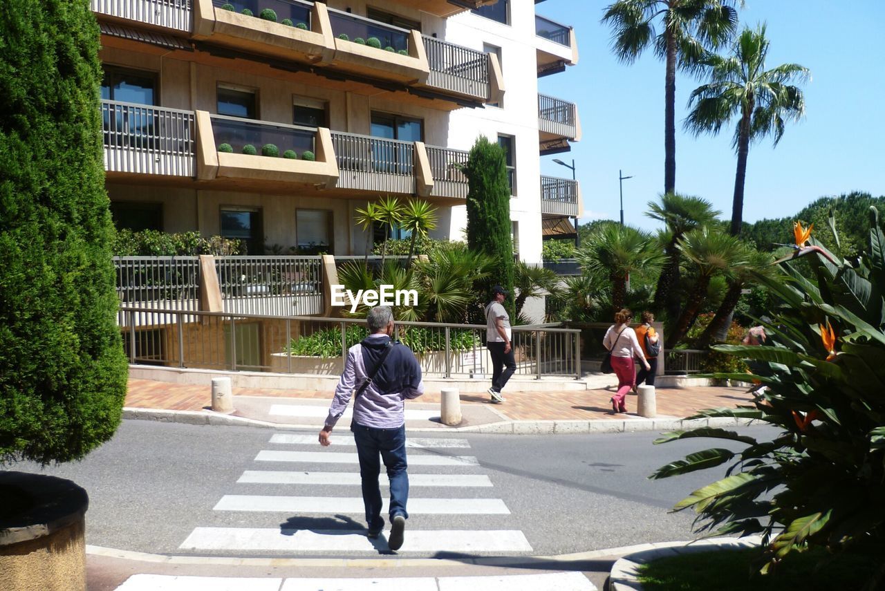 WOMAN WALKING ON ROAD IN CITY