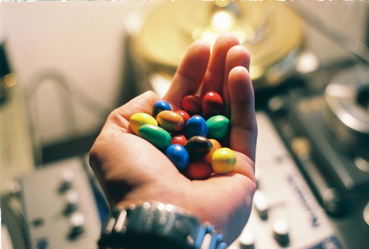 Cropped hand of man holding colorful candies