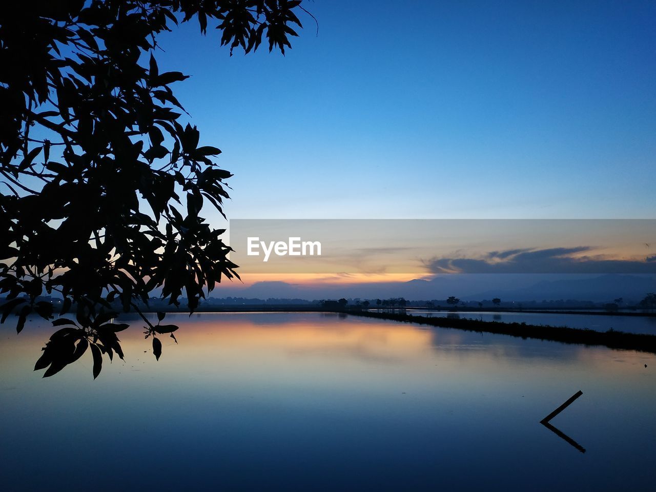 Scenic view of lake against sky during sunset